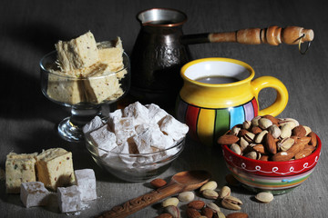 A mug of coffee and different oriental sweets: turkish delight, halva, almond and pistachio