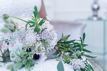  Bride holds a wedding bouquet. Very nice young woman in a white wedding dress holding a beautiful blossoming flower bouquet of various kinds of fresh real flowers, in pink, red and pastel cream color