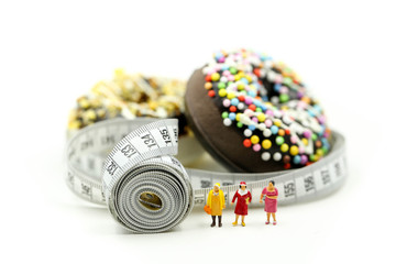 Miniature people : Fat woman and friend with Donut tying by measuring tape,dietary for slim shape concept.