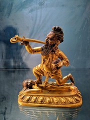 A statuette of a Buddhist deity who blows a trumpet made from a human thigh bone.