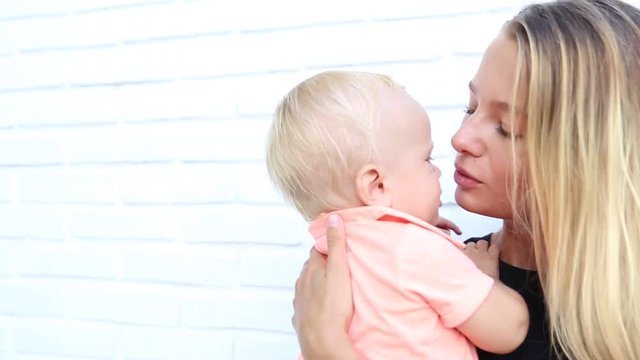 Young mother trying to cheer her cutre baby in ourdoor.