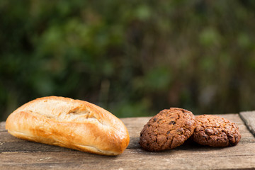 Assortment of fresh baked goods wooden background. baguette and cookies in the open space