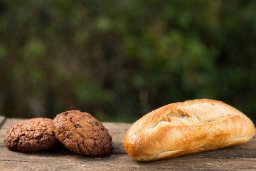 Assortment of fresh baked goods wooden background. baguette and cookies in the open space