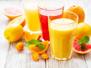 Glasses of juice and citrus fruits