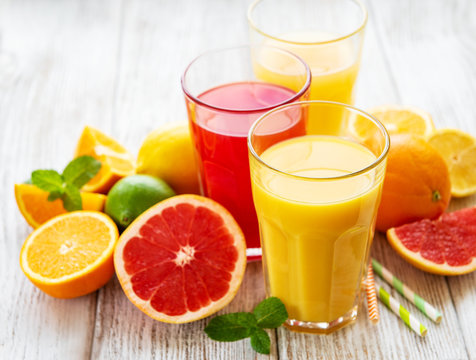 Glasses of juice and citrus fruits