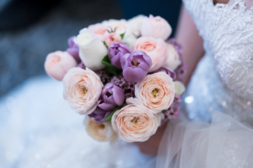 Bride holds a wedding bouquet. Very nice young woman in a white wedding dress holding a beautiful blossoming flower bouquet of various kinds of fresh real flowers, in pink, red and pastel cream color