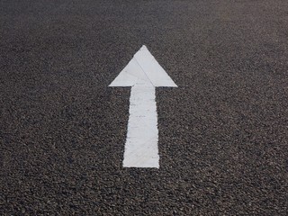 white arrow painted on asphalt