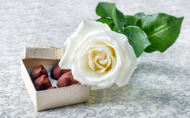 Beautiful white rose with golden gift box and chocolate truffles for Valentine's Day