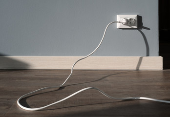 Power cord cable plugged into wall outlet