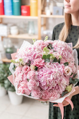beautiful fresh cut bouquet of mixed flowers in woman hand. the work of the florist at a flower...