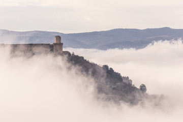 Fototapeta na wymiar A view of Rocca Maggiore castle in Assisi (Umbria, Italy) in the middle of fog