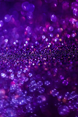 Purple glitter magic background. Defocused light and free focused place for your design.