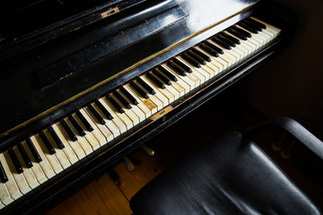 Old vintage wooden carved piano in dark room