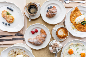Breakfast. Croissants, coffee and many different dishes on the table in the restaurant. Frittata - italian omelet. Omelette with tomatoes, avocado, spinach and soft cheese.