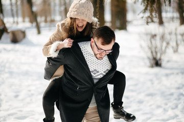 Fototapeta na wymiar Young Beautiful Couple Taking Fun and Smiling Outdoors in Snowy Winter