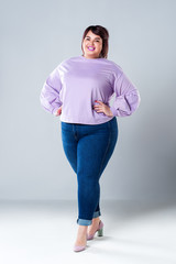 Plus size fashion model in casual clothes, fat woman on gray background