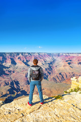 Fototapeta premium Young guy on the edge of a cliff on the Grand Canyon.
