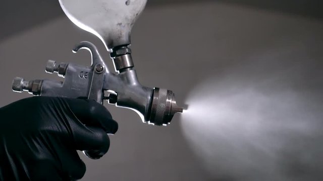 car body workshop paint spray close up slow motion