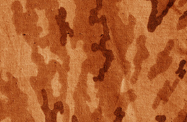 Old camouflage cloth texture in orange tone.