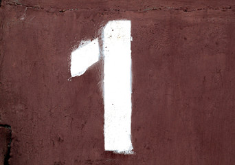 Number 1 in stencil on metal wall.