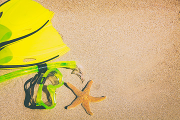 Beach vacation tropical watersport activity family leisure fun snorkel sport tropical background - top view on sand for copy space with yellow flippers and mask. © Maridav