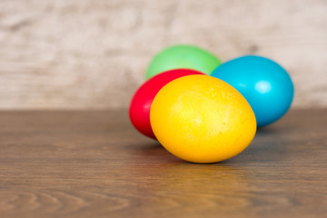 red, yellow, green and blue easter eggs on wooden table
