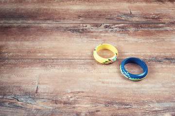 Close-up image of an yellow and blue bracelets on brown wooden background.
