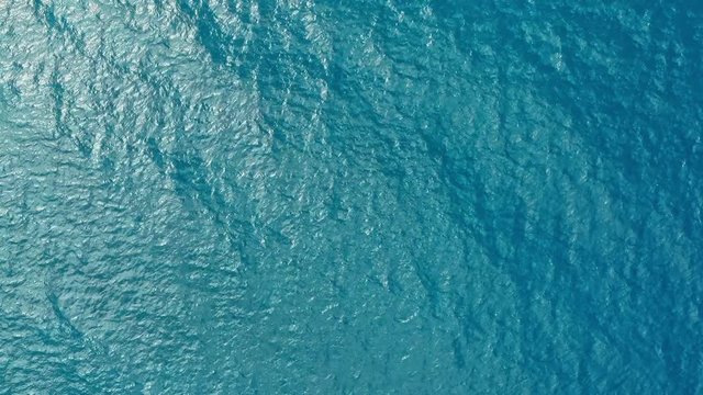 aerial drone footage of the deep blue clear sea ocean water with small waves rolling