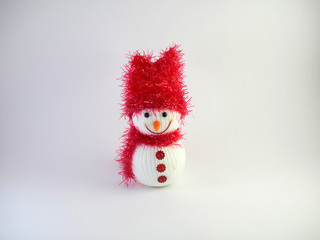 smiling snowman toy dressed in scarf and cap isolated on white background