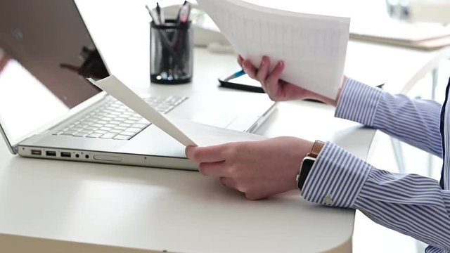 会議に必要な資料を準備、作成する女性。書類に情報を書き込む動作。