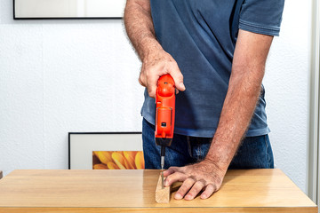 Man placing a screw with an electric screwdriver