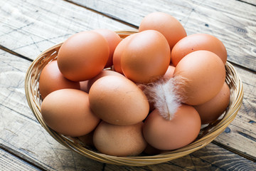 Fresh chicken eggs in the basket. Rustic wooden style background.