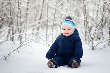 Fototapeta na wymiar baby boy sitting on snow