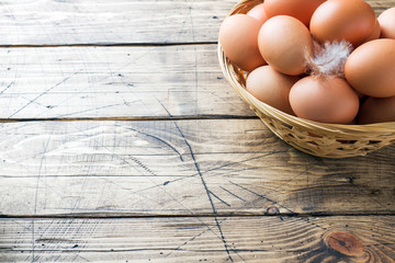 Fresh chicken eggs in the basket. Rustic wooden style background. Copy space