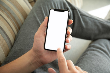male hands holding phone with isolated screen on the sofa