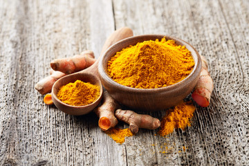 Turmeric spice in wooden board
