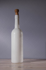 Wine white bottle stands on a wooden table