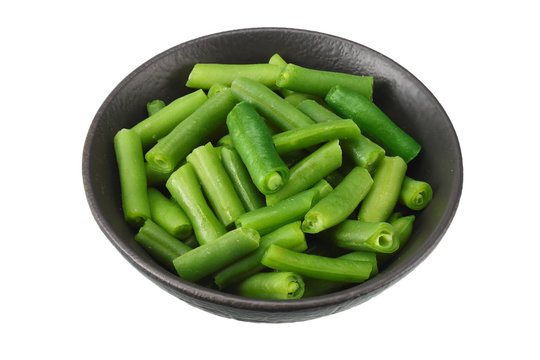 cut green beans in wooden bowl isolated on white background.