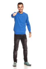 handsome happy young man in blouse and jeans  on white background showing thumbs up