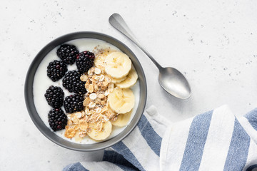 Breakfast bowl with granola, fruits and yogurt. Table top view. Healthy breakfast, healthy eating and dieting concept