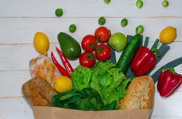 Paper bag of different health food on white wooden background. Top view.