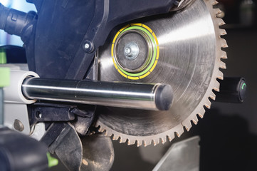 Close-up manual circular saw on slides for sawing wood in the home workshop