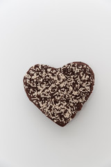 Chocolate heart-shaped topping with granulated chocolate. Celebration for Valentine's Day or Mother's Day. Isolated on white background. Top view. Space for text. Vertical image.
