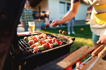 Close up of grilled vegetables and meat on sticks on grill. Family gathering concept.