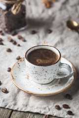 Hot Coffee cup and coffee beans on the wooden table, rustic style