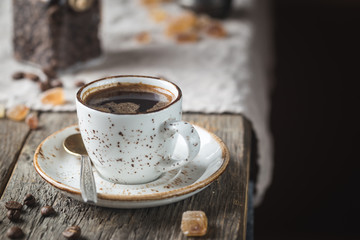 Hot Coffee cup and coffee beans on the wooden table, rustic style