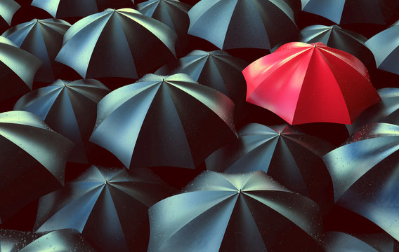 Ein roter Regenschirm zwischen vielen schwarzen Regenschirmen