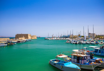 Fototapeta na wymiar Fishing boats and Venetian Fortress in Heraklion, Crete, Greece