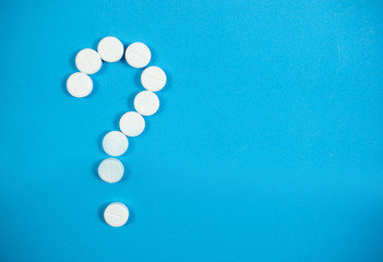 Medical background with multi-colored packs of pills. Сoncept pharmacy, clinic, drugs, headache medicine. Image on illness, flu, treatment. White question mark from pills