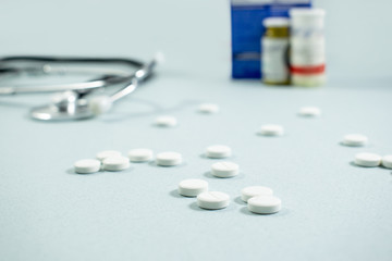 Medical background with with statoscope and pills. Сoncept pharmacy, clinic, drugs, headache medicine. Image on illness, cardiology, treatment